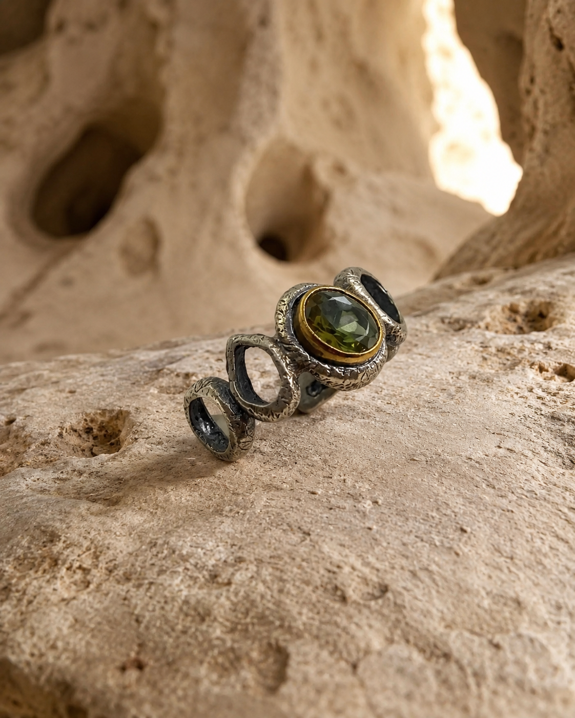 Organic loop 925 sterling silver ring with oval zultanite stone and gold-toned bezel on white background