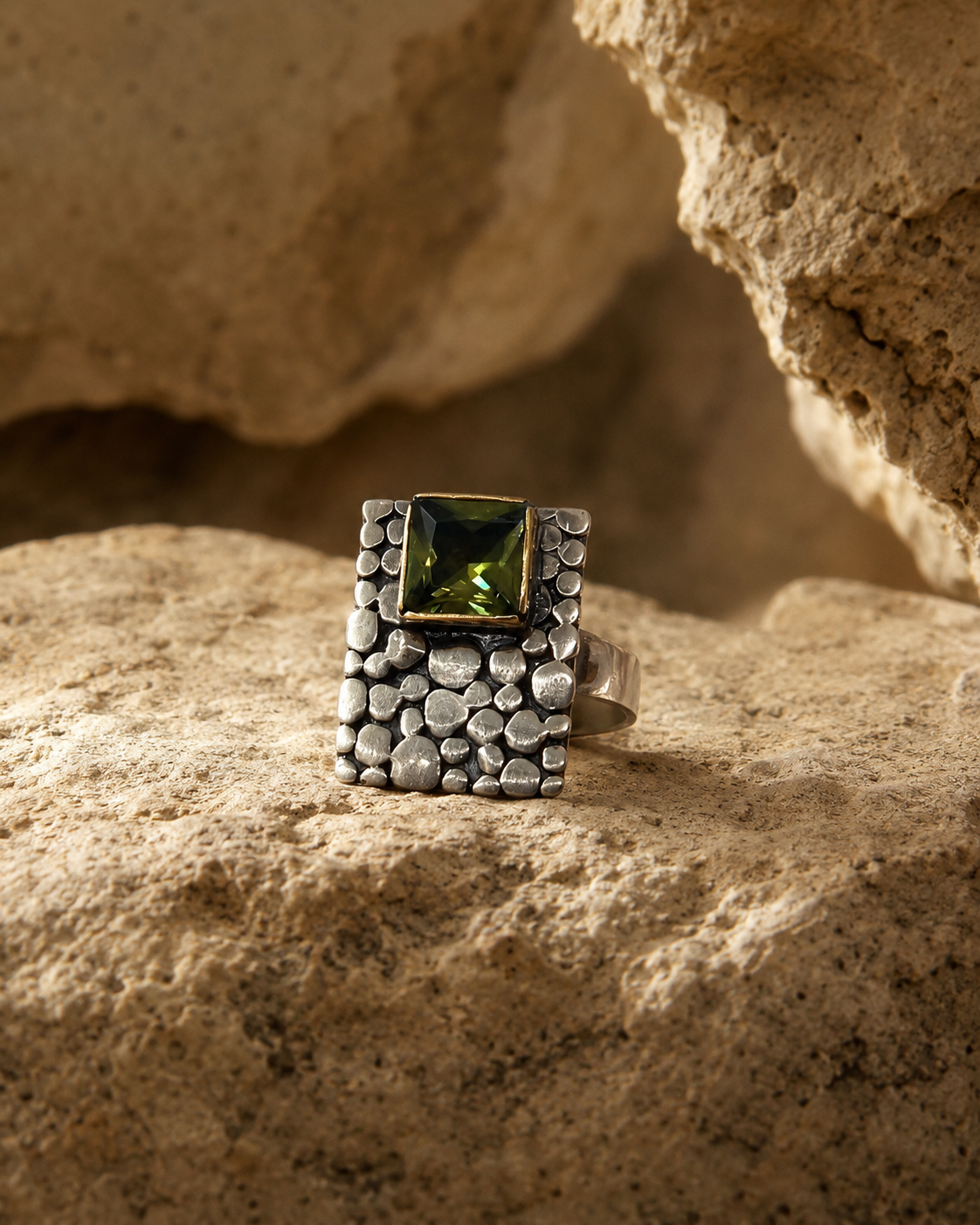 Anillo de plata 925 con piedra zultanita cuadrada, placa texturizada y detalles dorados sobre fondo blanco