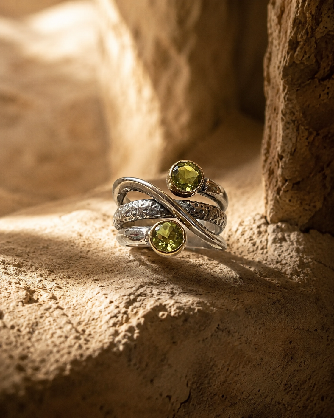Cross band 925 sterling silver ring with two round zultanite stones and gold-toned bezels on white background
