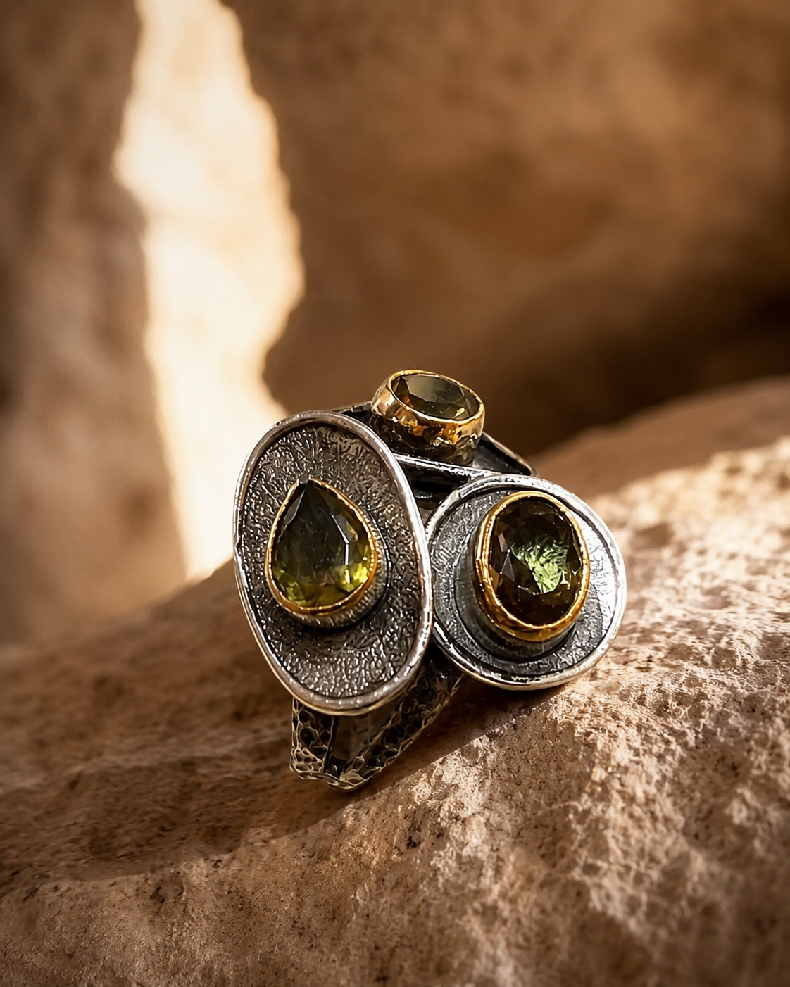 Asymmetric 925 sterling silver ring with three zultanite stones and gold-toned bezel details on white background