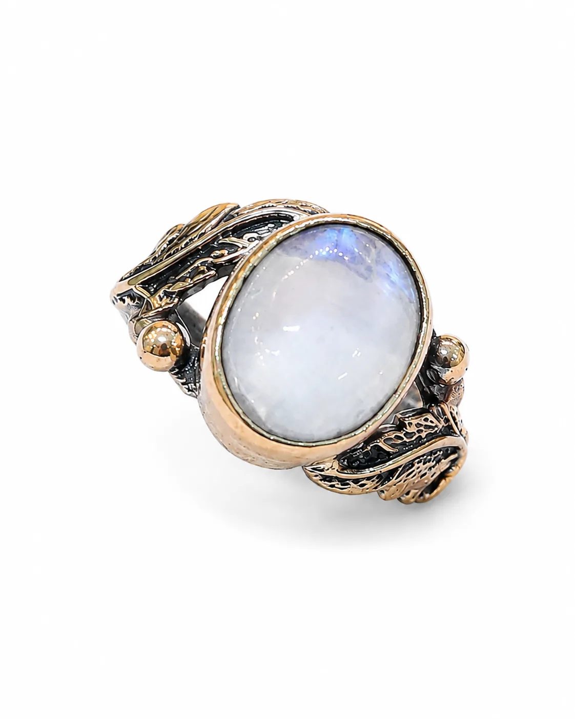 Moonstone silver ring with bronze-toned bezel, side accents and botanical details on a white background