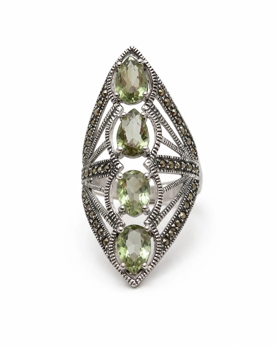 Elongated zultanite and marcasite silver statement ring with four green faceted gemstones on a white background