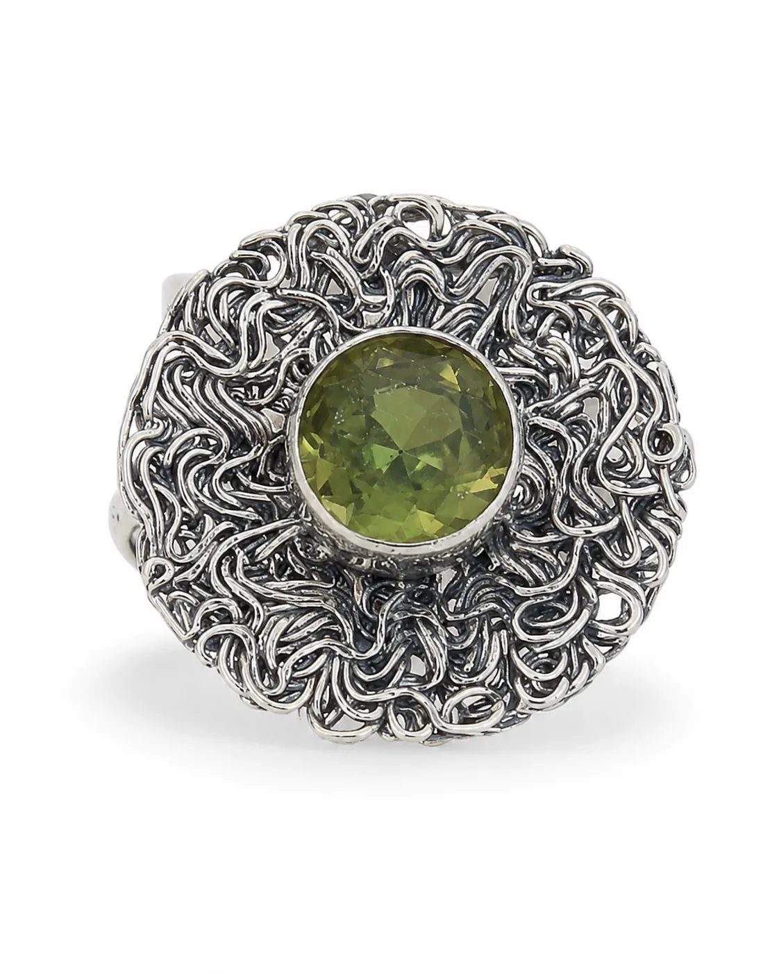 Ornate zultanite silver statement ring with a round green faceted gemstone and intricate oxidized openwork on a white background