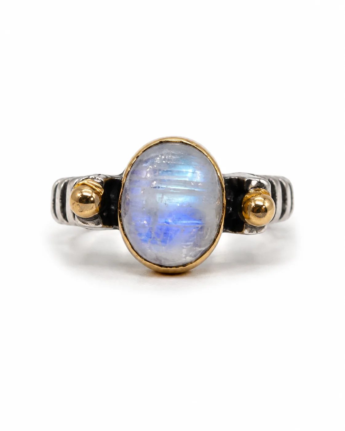 Silver moonstone ring with bronze-toned bezel and side accents on a white background