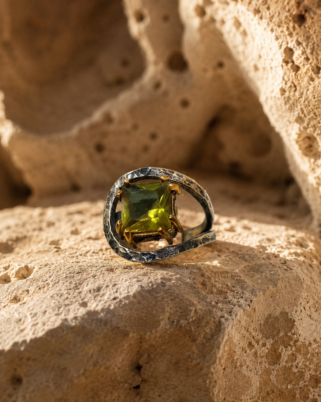 Open frame 925 sterling silver ring with square zultanite stone and gold-toned claw details on white background