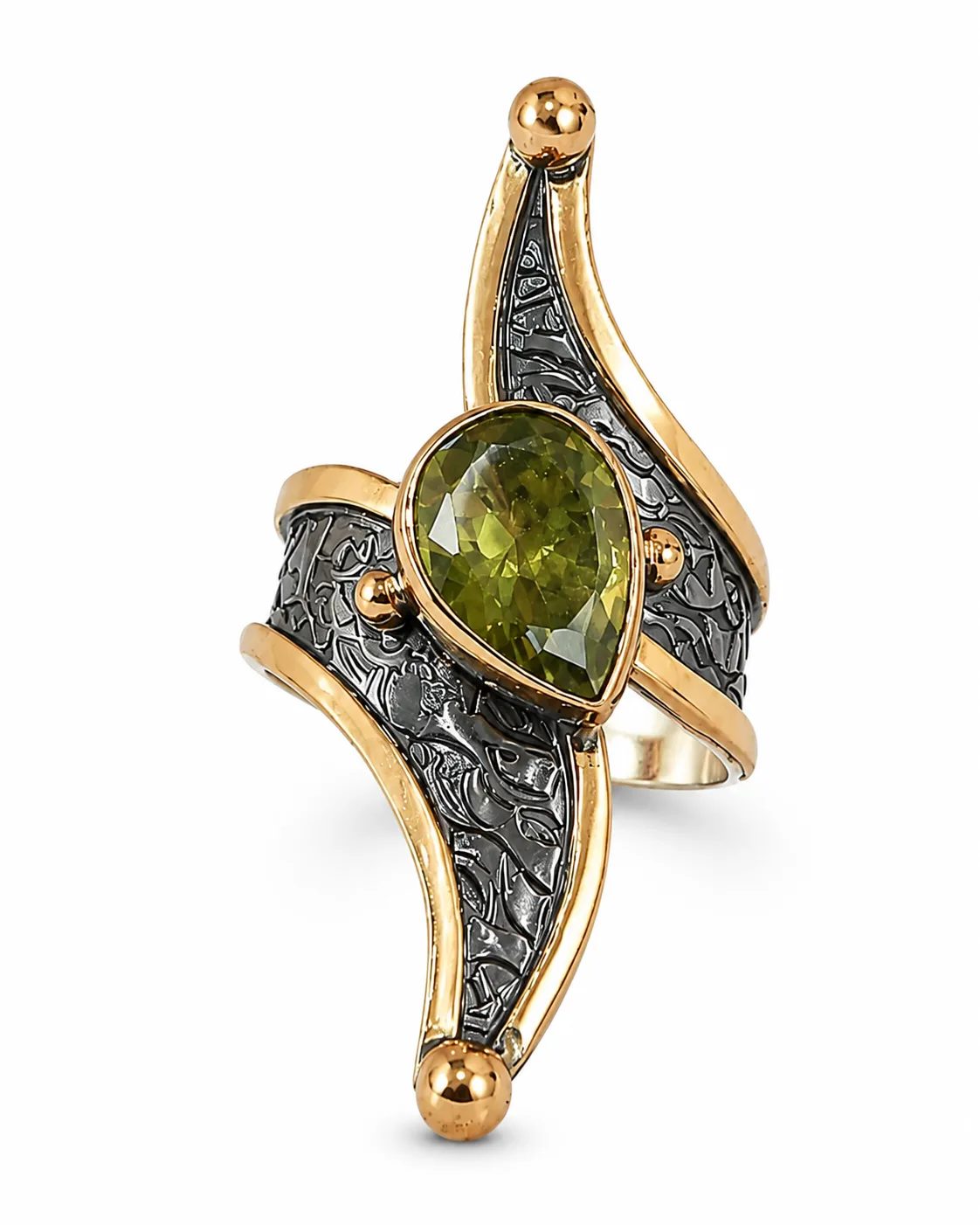 Elongated zultanite mixed metal statement ring with a pear-shaped green gemstone and oxidized decorative detailing on a white background